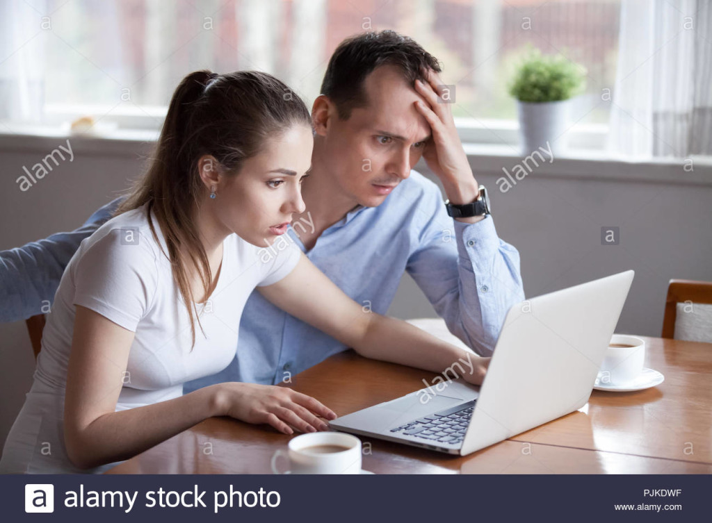 young-couple-disappointed-getting-bad-news-email-on-laptop-PJKDWF